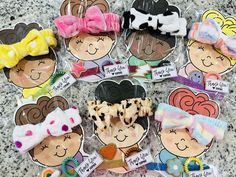 several different hair clips are arranged on a table with stickers in the shape of children's faces