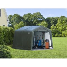 an outdoor storage shed in the middle of a yard with tools and equipment inside it