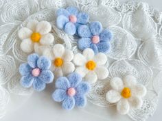 several small blue and white flowers are on a lace doily that is laying down