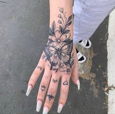 a woman's hand with tattoos and flowers on it