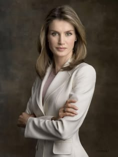 a woman with her arms crossed posing for a photo