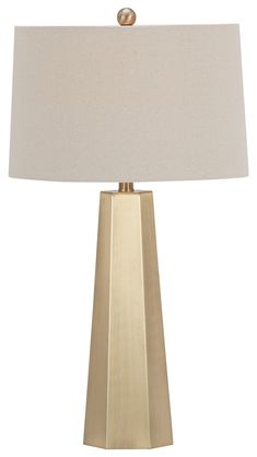 a gold table lamp with a white shade on the base and a beige linen lampshade