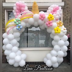 a balloon arch decorated with unicorns and balloons