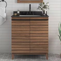 a bathroom vanity with a mirror above it and a plant on the counter next to it