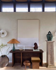 a table with two lamps and a painting on the wall