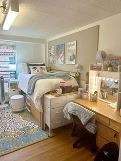 a bedroom with a bed, desk and dresser in it's corner area next to a window