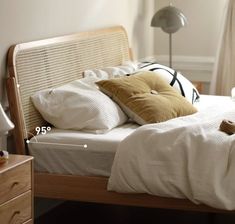 a bed with white sheets and brown pillows