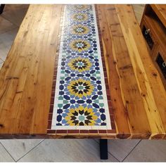 a wooden table with a colorful tile design on it