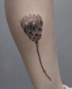 a woman's leg with a flower tattoo on the side of her thigh,