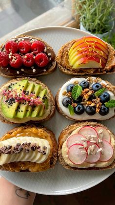 a white plate topped with sandwiches covered in fruit and veggies on top of each other