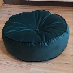 a large green bean bag sitting on top of a wooden floor