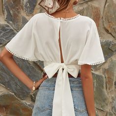 Feminine V-neck Tie Back Tops, Chic Vacation Tops With Tie Back, Chic Tie Back Tops For Vacation, Elegant Beach Top With Tie Back, Elegant Tie-back Tops For The Beach, Elegant Tie Back Top For Beach, White Tie Back Crop Top, Spring V-neck Blouse With Tie Back, Elegant Cotton Top With Tie Back