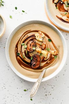 two white bowls filled with food on top of a table