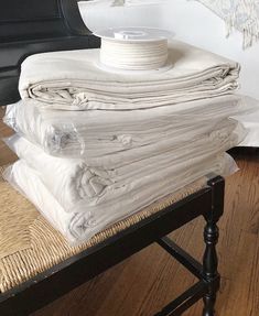 a stack of white blankets sitting on top of a wooden table