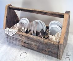 a wooden box filled with silverware on top of a table