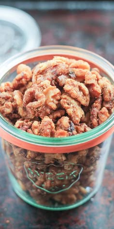 a glass bowl filled with walnuts on top of a table