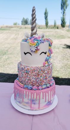 a cake decorated with sprinkles and a unicorn horn