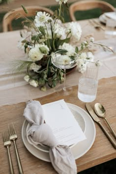 a place setting with napkins, silverware and flowers