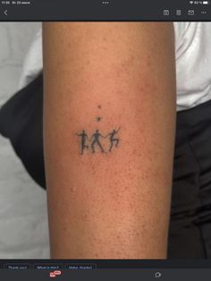 a person with a small tattoo on their arm that has three people walking in the same direction