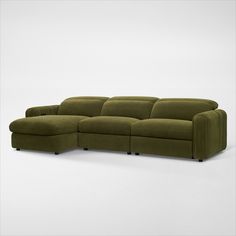 a green sectional sofa sitting on top of a white floor