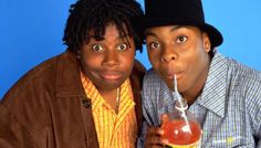 two people posing for the camera with a drink in front of their face and one holding a straw