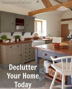 a kitchen with gray cabinets and wooden counter tops, an island in the middle is surrounded by wicker baskets