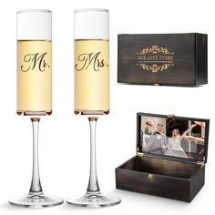 two champagne flutes in front of a box with a photo inside it and the words mr and mrs engraved on them