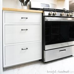 an oven and counter in a kitchen with white cabinets