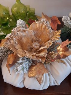 a white pumpkin decorated with gold and silver flowers