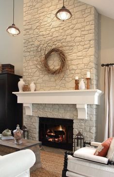 a living room filled with furniture and a fire place in front of a stone fireplace