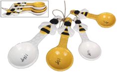 three yellow and white spoons are hanging from a string