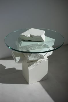 a glass table topped with three pieces of white cake sitting on top of each other