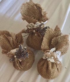 three burlap bags filled with flowers on top of a bed