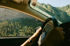 a view from inside a car looking at the mountains and trees