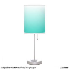 a table lamp with a blue shade on the base and a white drum light behind it