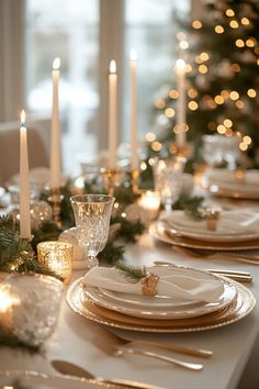 a table set for christmas with candles and plates