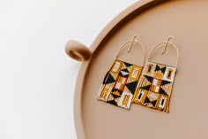 two pairs of beaded earrings sitting on top of a tray