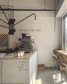 a coffee shop with tables and chairs in front of the window that says forget me not