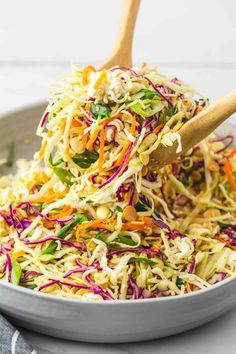 a bowl filled with coleslaw slaw and wooden spoon in the side dish