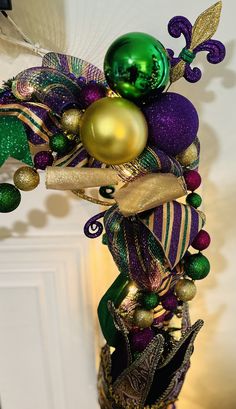 a tall green and purple christmas tree with ornaments