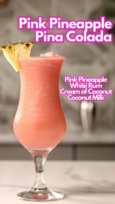 pink pineapple pina cola in a tall glass with a slice of pineapple on top