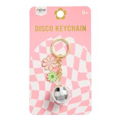 a keychain with a flower on it in front of a pink and white checkered background