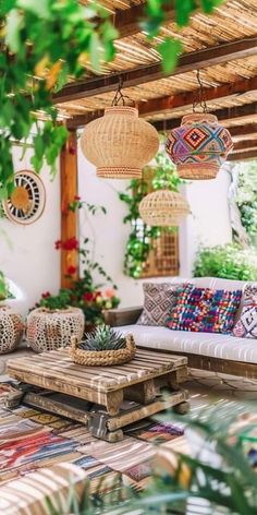 an outdoor living room with wicker furniture and plants on the walls, hanging from rafters