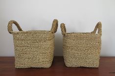 two woven baskets sitting on top of a wooden table