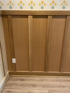 an empty bathroom with wooden doors and tile flooring on the walls, along with wallpaper