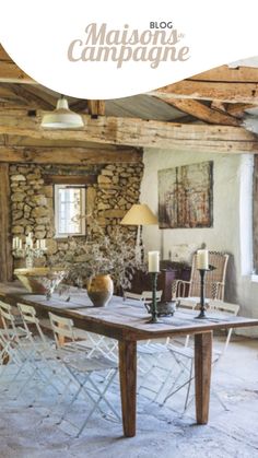 a table and chairs in front of a stone wall with the words maison des campagne on it