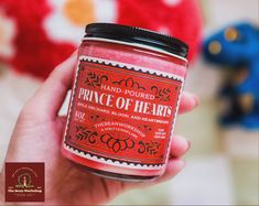 a hand holding a jar of pink colored powder