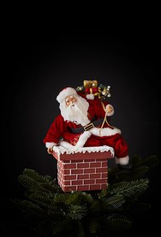 a santa clause sitting on top of a brick chimney