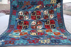 a large blue quilt with red and green designs on it