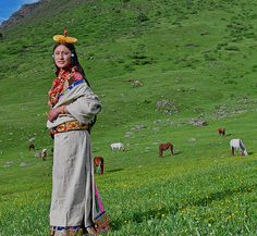 a woman standing in the middle of a field